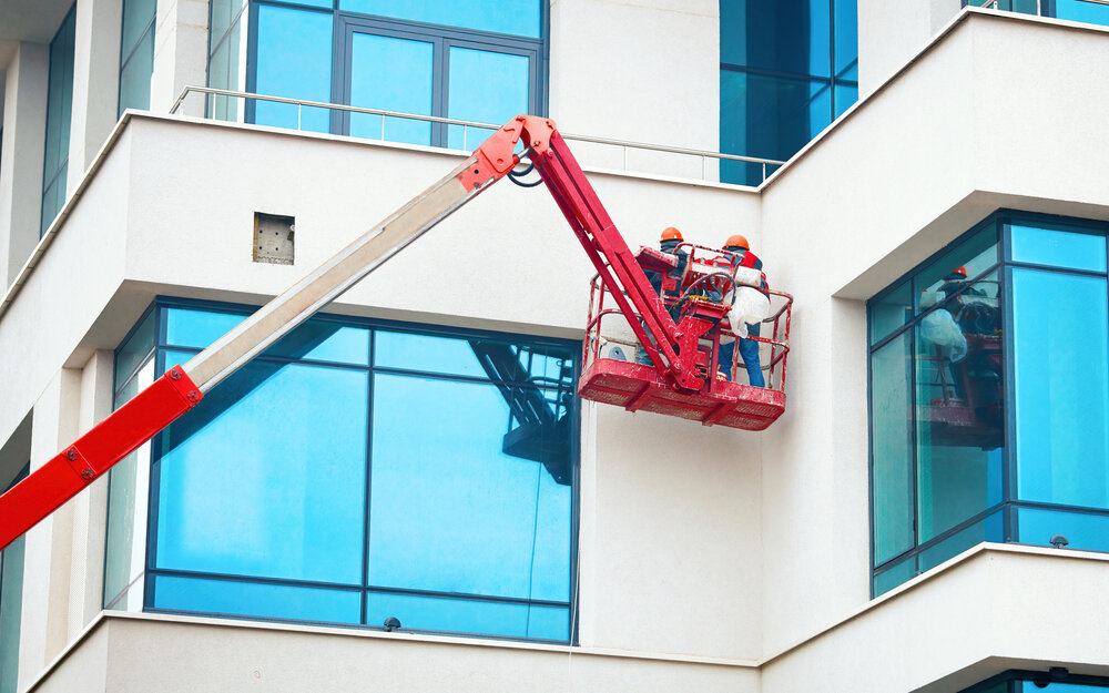 Commercial Painting. Men In Hardhat Paint commercial Building.