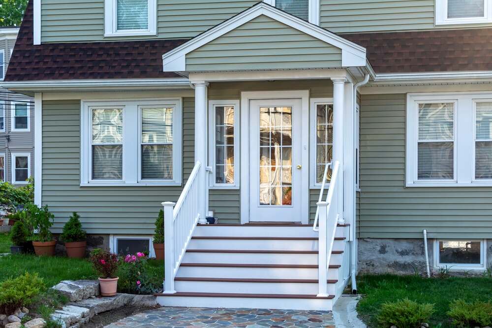 Islanders’ Choice Painting. Freshly painted Traditional residential style home with multi-pane glass door and gabled portico.