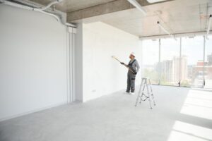Top-Notch Victoria Painting Services. Commercial Painting Services. Painter painting the office wall with roller paint. 
