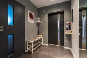 Why Choose Islanders’ Choice for Strata Painting in Victoria? Interior common area painting to refresh hallways, stairwells. Cozy hall with front door and grey decor.